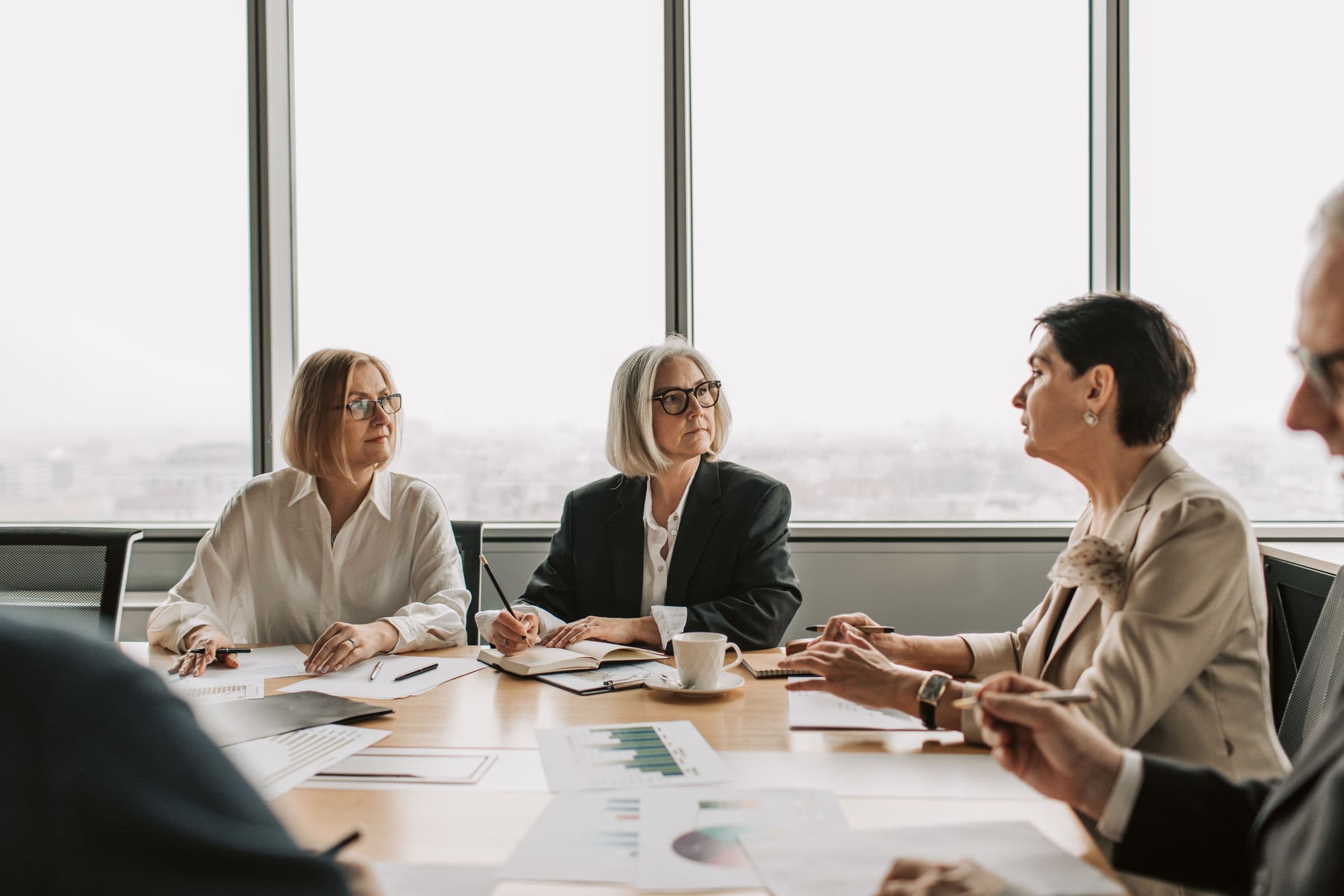Senior professionals reviewing documents around a boardroom table