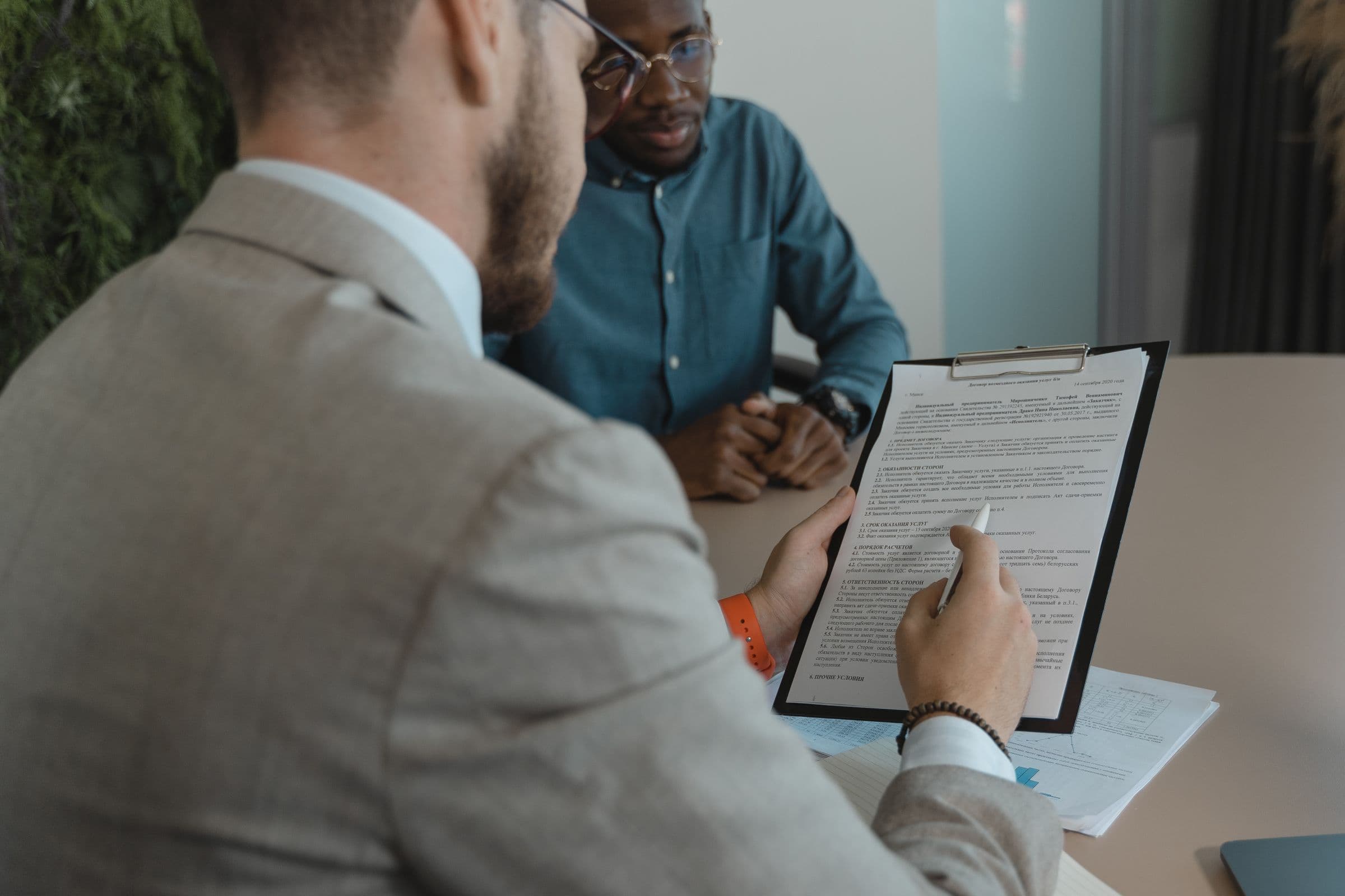 A manager reading a service agreement across a meeting table