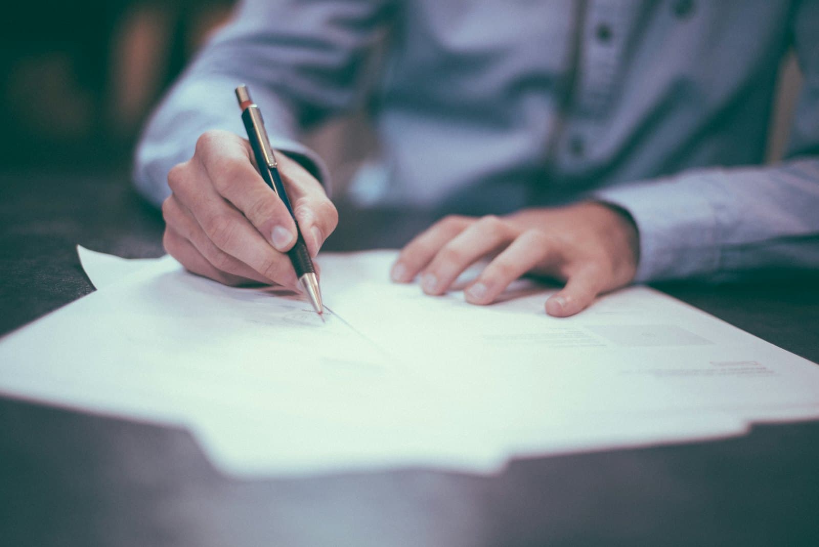 A screening specialist verifying records across multiple sources at a desk
